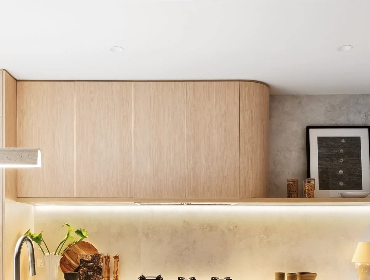 Timber cabinetry, stone benchtop and warm integrated lighting in a Carlton North kitchen