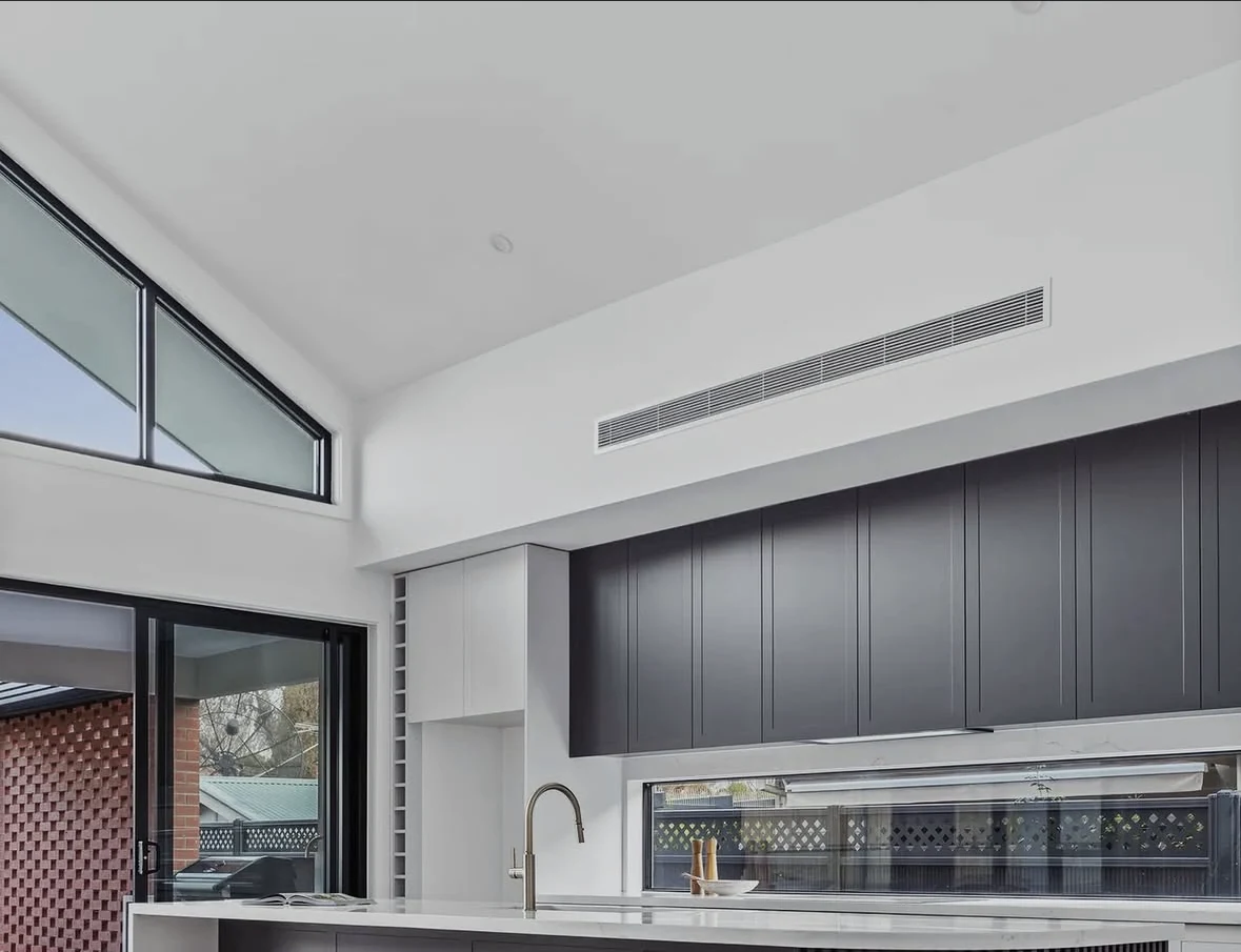 Dark cabinetry, timber floor and long kitchen island in a contemporary Melbourne home